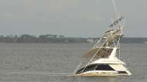 The tide rises on a half-sunk boat in the bay.